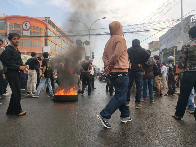 Demonstran mengelilingi ban yang dibakar. Dok: kumparan.