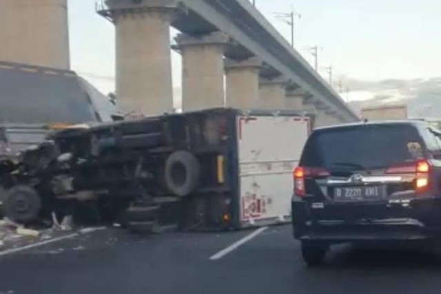 Sebuah truk terguling di Tol Jati Bening Km. 06 menjelang exit Pondok Gede arah Jakarta, Rabu (12/4/2023). Foto: Twitter/@TMCPoldaMetro