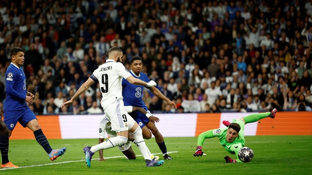 Pemain Real Madrid Karim Benzema mencetak gol pertama mereka melewati kiper Chelsea Kepa Arrizabalaga di Santiago Bernabeu, Madrid, Spanyol, Rabu (12/4/2023). Foto: Juan Medina/REUTERS