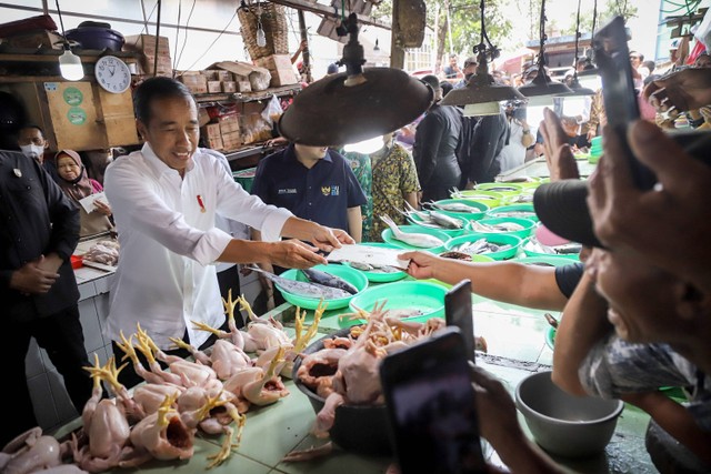 Presiden Jokowi memberikan bantuan kepada pedagang saat berkunjung ke Pasar Minggu, di Jakarta Selatan, Kamis (13/4/2023). Foto: Jamal Ramadhan/kumparan