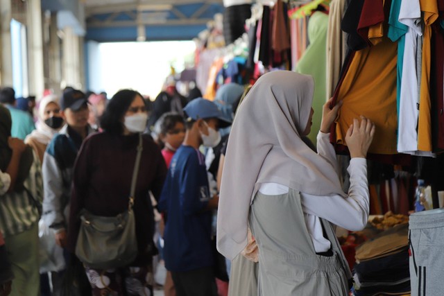Sejumlah warga melihat barang di salah satu penjual di Skybridge Pasar Tanah Abang, Jakarta, Sabtu (15/4/2023). Foto: Jamal Ramadhan/kumparan