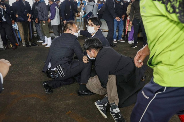 Seorang pria diamankan polisi setelah melemparkan benda mirip pipa ke Perdana Menteri Jepang Fumio Kishida, di Wakayama, Prefektur Wakayama, Jepang barat daya, Sabtu (15/4/2023). Foto: Kyodo/via REUTERS