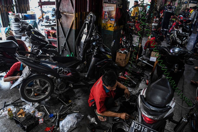 Mekanik memperbaiki motor di salah satu bengkel motor di Pasar Minggu, Jakarta Selatan, Minggu (16/4/2023). Foto: Sigid Kurniawan/ANTARA FOTO