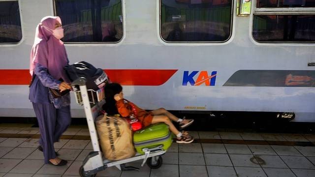 Seorang ibu membawa anaknya hendak berangkat mudik menggunakan kereta api di Stasiun Kertapati Palembang jelang arus mudik lebaran 2023, Foto: abp/Urban Id