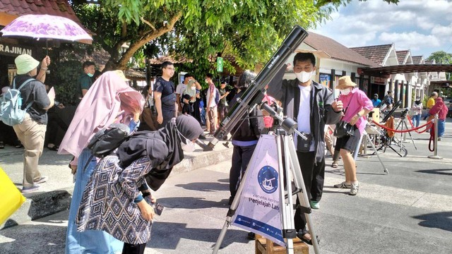 Wisatawan menyaksikan gerhana matahari di area Taman Pintar. Foto: Maria Wulan/Tugu Jogja