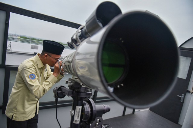 Petugas Observatorium Ilmu Falak Universitas Muhammadiyah Sumatera Utara (OIF UMSU) melakukan pengamatan rukyatul hilal mengunakan teropong di Medan, Kamis (20/4/2023). Foto: Fransisco Carolio/ANTARA FOTO