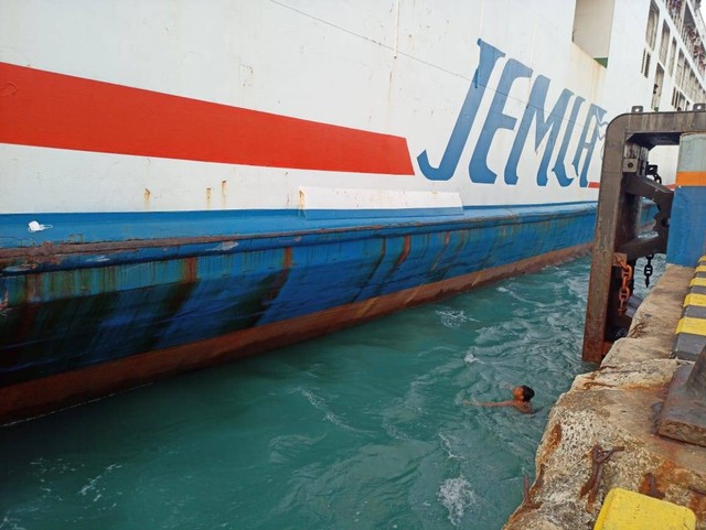 Anak logam melakukan aksinya mencebur ke laut demi mendapatkan uang koin dari penumpang kapal. | Foto : Galih Prihantoro/ Lampung Geh