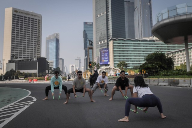 Warga melakukan pound fit di Jalan MH Thamrin yang sepi saat lebaran, Sabtu (22/4/2023). Foto: Jamal Ramadhan/kumparan