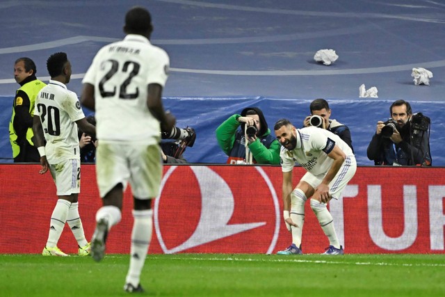 Penyerang Real Madrid, Karim Benzema, bereaksi setelah cedrea saat merayakan gol ke gawang Liverpool dalam laga leg kedua babak 16 besar Liga Champions 2022/23 di Stadion Santiago Bernabeu pada 15 Maret 2023. Foto: JAVIER SORIANO / AFP