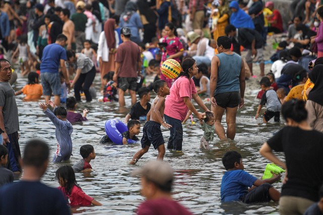 Sejumlah pengunjung bermain di kawasan pantai Ancol, Jakarta, Minggu (23/4/2023). Foto: M Risyal Hidayat/Antara Foto 