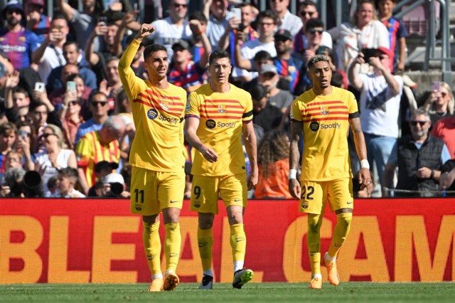 Ferran Torres (kiri) merayakan golnya bersama Robert Lewandowski dan Raphinha dalam pertandingan Liga Spanyol 2022/23 antara Barcelona vs Atletico Madrid di Stadion Camp Nou, Barcelona, Spanyol, pada Minggu (23/4). Foto: Josep Lago/AFP