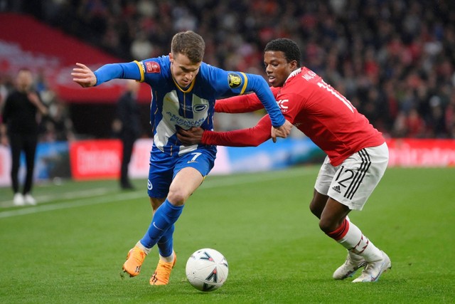 Pemain Manchester United Tyrell Malacia berebut bola dengan pemain Brighton & Hove Albion Solly March pada pertandingan semifinal Piala FA di Stadion Wembley, London, Inggris Minggu (23/4/2023).  Foto: Toby Melville/REUTERS