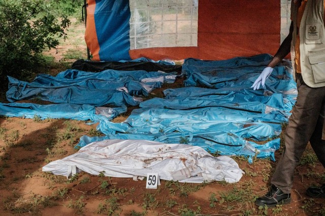 Jenazah yang digali dalam kantong mayat dipajang di tanah sebelum diangkut ke kamar mayat, di situs kuburan massal di Shakahola, di luar kota pesisir Malindi, Kenya, pada 25 April 2023. Foto: Yasuyoshi Chiba/AFP