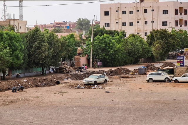 Mobil diparkir di dekat parit di Khartoum saat pertempuran berlanjut antara tentara Sudan dan pasukan paramiliter, Kamis (27/4/2023). Foto: AFP