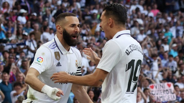 Karim Benzema dari Real Madrid merayakan gol pertamanya dengan Dani Ceballos dari Real Madrid saat pertandingan Liga Spanyol 2022/23 di Stadion Santiago Bernabeu, Madrid. Foto: Isabel Infantes/Reuters