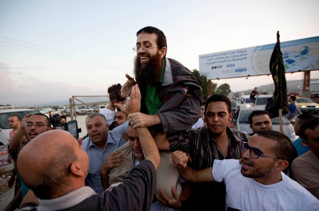 Warga Palestina Khader Adnan (tengah) disambut oleh warga Palestina setelah dibebaskan dari penjara Israel di desa Arrabeh Tepi Barat dekat Jenin, Minggu, 12 Juli 2015. Foto: Majdi Mohammed/AP Photo