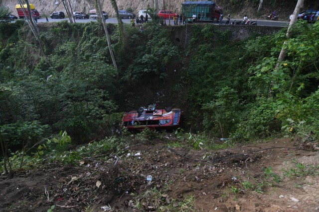 Sejumlah pengendara mengamati bus pengangkut santri yang masuk ke jurang di kawasan Pegunungan Kebun Kopi di Parigi Moutong, Sulawesi Tengah, Kamis (4/5/2023). Foto: Mohamad Hamzah/Antara Foto