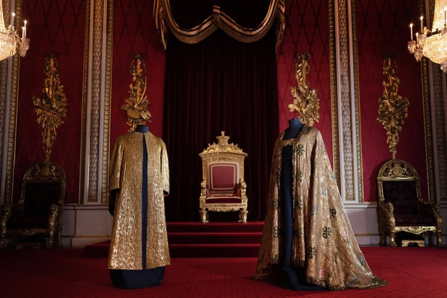 Jubah Supertunica (kiri) dan Imperial Mantle dipajang di Ruang Tahta di Istana Buckingham di London pada 26 April 2023. Foto: Victoria Jones / POOL / AFP