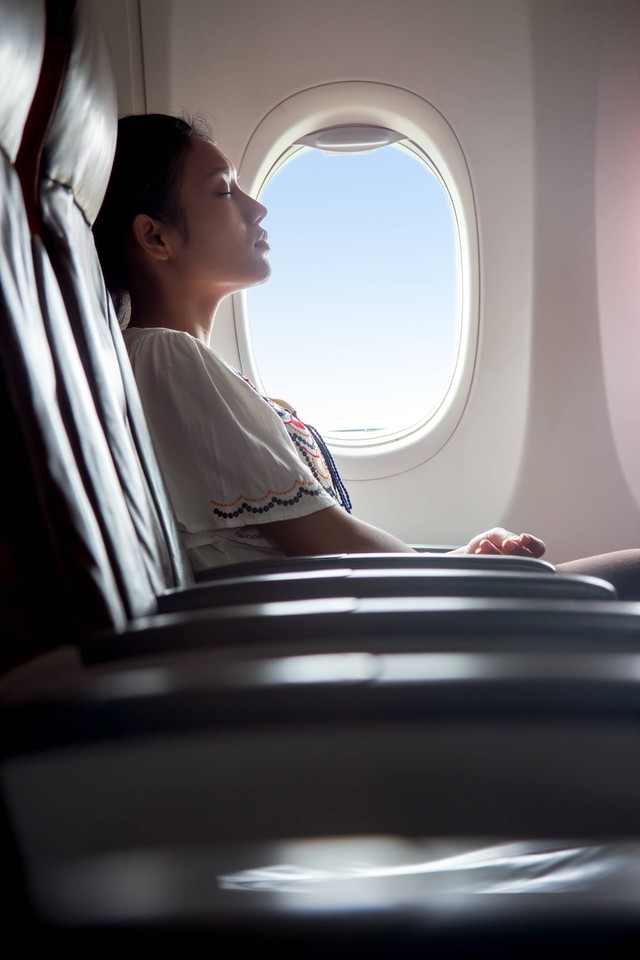 Ilustrasi penumpang tidur di pesawat. Foto: Milkovasa/Shutterstock