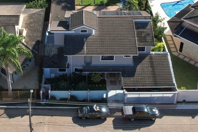 Mobil polisi federal Brasil terlihat di depan rumah mantan Presiden Brasil Jair Bolsonaro, selama operasi pencarian di rumahnya, di Brasilia, Brasil, Rabu (3/5/2023). Foto: Ueslei Marcelino/REUTERS