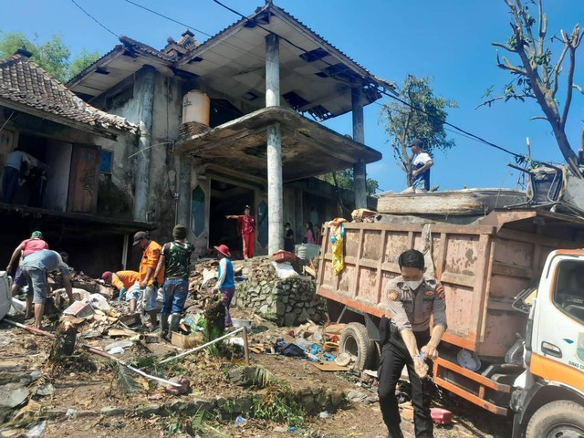 Warga dan para relawan membersihkan rumah dokter Wayan di hari keempat, Jumat (5/1). Foto: Dok. Istimewa