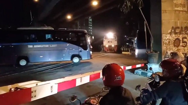 Tangkapan layar video 2 bus TNI terobos palang kereta api. Foto: Twitter/@sahabat_kereta