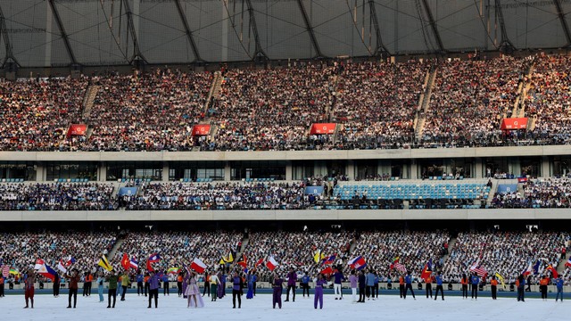 Penampil membawa bendera negara peserta selama upacara pembukaan SEA Games 2023, di Stadion Nasional Morodok Techo, Phnom Penh, Kamboja, Jumat (5/5/2023). Foto: Kim Kyung-Hoon/REUTERS