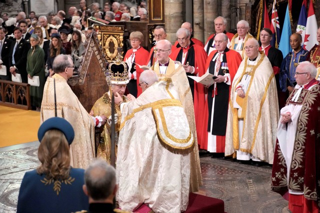 Raja Charles III duduk saat menerima The St Edward's Crown saat upacara penobatan di Westminster Abbey, London, Sabtu (6/5/2023). Dok: Jonathan Brady/Pool Photo via AP