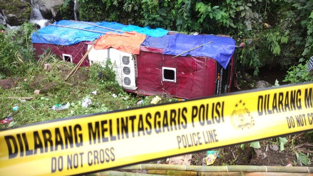 Satu unit bus dalam posisi terbalik usai jatuh ke dalam jurang di kawasan objek wisata Guci, Kabupaten Tegal, Jawa Tengah, Minggu (7/5/2023). Foto: Antara Foto