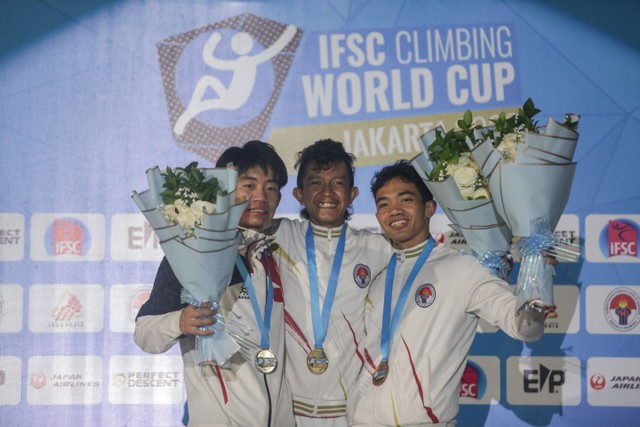 Altet panjat tebing Indonesia Raharjati Nursamsa (tengah) bersama rekannya Kiromal Katibin (kanan) dan atlet panjat tebing Cina Wang Xinshang (kiri) berada di atas podium usai mengikuti final nomor speed Kejuaraan Dunia Panjat Tebing. Foto: Hendra Nurdiyansyah/Antara Foto