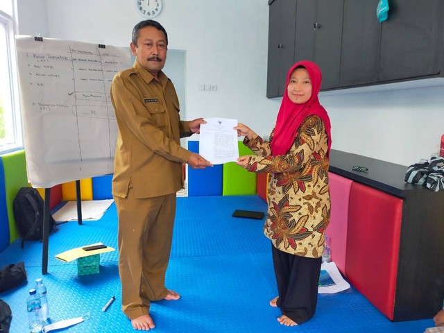 Yuyun menerima Surat Keputusan (SK) dari Kepala Desa Tuwel sebagai koordinator Rumah Anak SIGAP. 