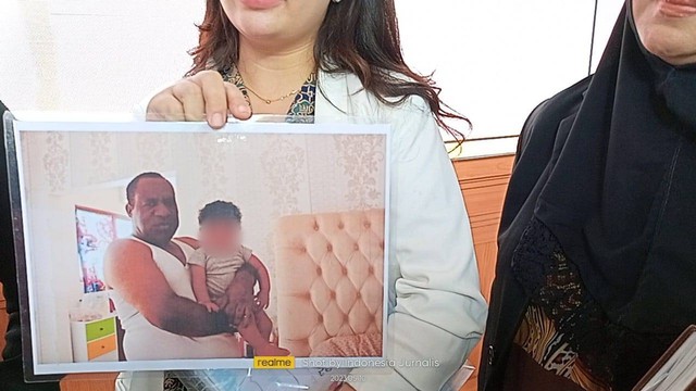 Veronica Jennifer, wanita yang digugat oleh Wamendagri John Wempi Wetipo, menunjukkan bukti foto Wempi gendong anaknya. Foto: kumparan