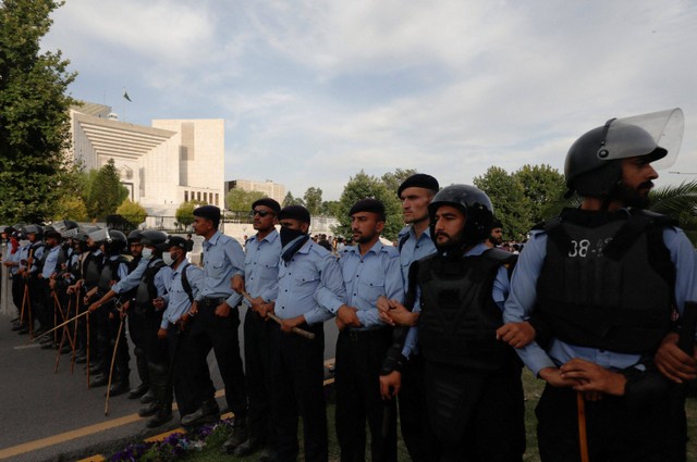 Polisi bersiap menghentikan pendukung mantan Perdana Menteri Pakistan, Imran Khan, saat ia menghadap Mahkamah Agung di Islamabad, Pakistan, Kamis (11/5/2023). Foto: Akhtar Soomro/Reuters