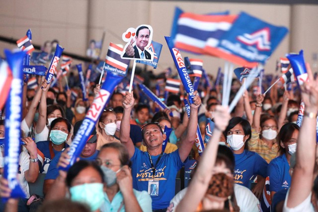 Pendukung memegang plakat bergambar Perdana Menteri Thailand Prayuth Chan-ocha dan calon perdana menteri, di acara rapat umum Partai Persatuan Bangsa Bangsa Thailand menjelang pemilihan umum mendatang, di Bangkok, Thailand, 12 Mei 2023. Foto: REUTERS/Stringer