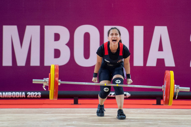 Atlet angkat besi Indonesia Juliana Klarisa meluapkan kegembiraan usai melakukan angkatan snatch terbaiknya pada perlombaan kelas 55 kilogram putri SEA Games 2023 di Taekwondo Hall, Olympic Complex, Phnom Penh, Kamboja, Minggu (14/5/2023). Foto: M Agung Rajasa/Antara Foto