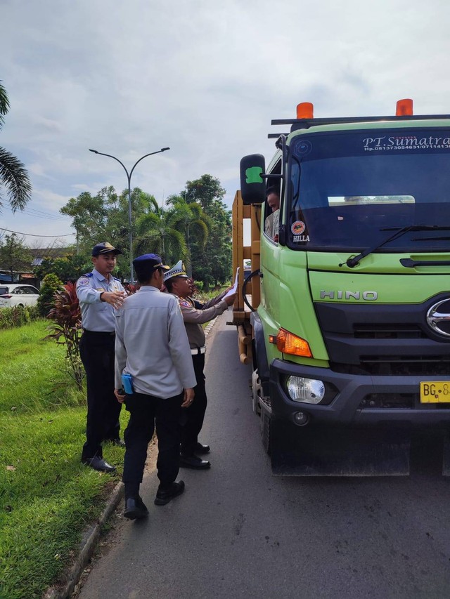 Tim gabungan Dishub dan polisi saat menindak truk bertonase berat yang melanggar jam operasional. (ist)
