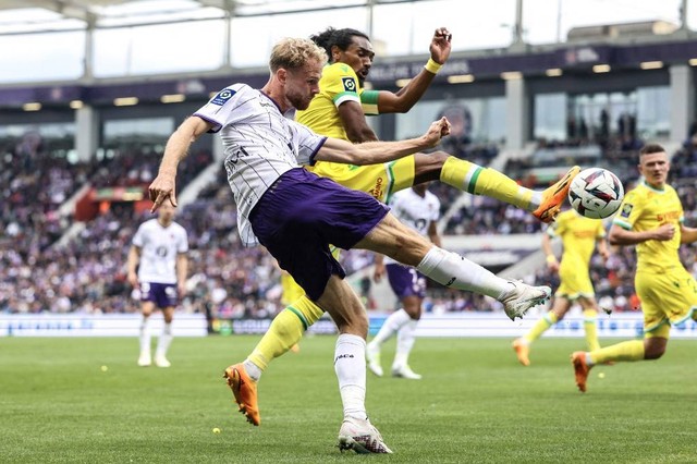 Bek Toulouse, Mikkel Desler Puggaard (kiri), berduel dengan pemain Nantes, Samuel Moutoussamy (kanan), dalam lanjutan Liga Prancis 2022/23 di Stadion Municipal, Toulouse, Prancis, Minggu (14/5) Foto: Charly Triballeau/AFP