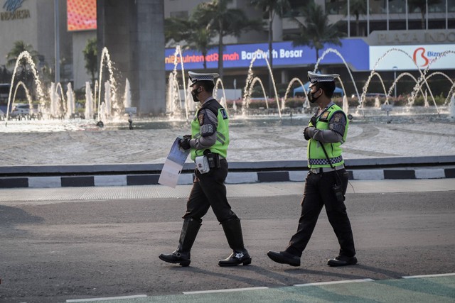 Petugas kepolisian lalu lintas menilang pengendara yang melanggar aturan lalu lintas di kawasan Bundaran Hotel Indonesia, Jakarta, Selasa (16/5/2023).
 Foto: Jamal Ramadhan/kumparan