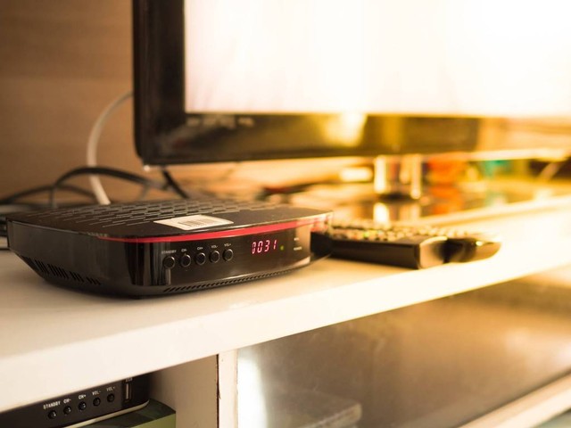 Ilustrasi cara menyalakan TV denagn remote set top box. Foto: Shutterstock