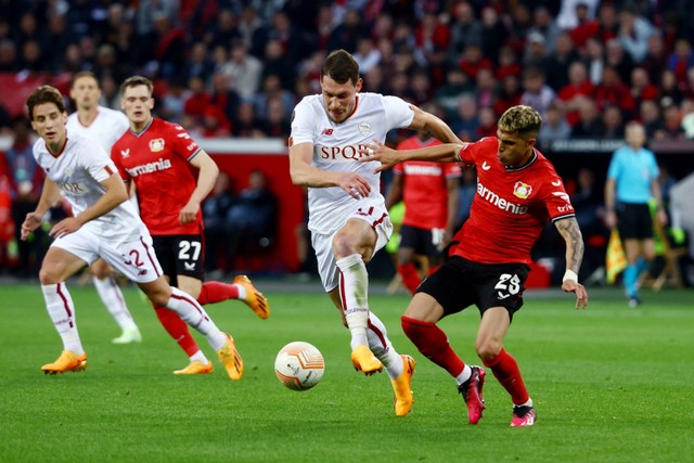 Pemain Bayer Leverkusen Exequiel Palacios berebut bola dengan pemain AS Roma Andrea Belotti pada pertandingan leg kedua semifinal Liga Europa di Bay Arena, Leverkusen, Jerman, Jumat (19/5/2023). Foto: Kai Pfaffenbach/REUTERS