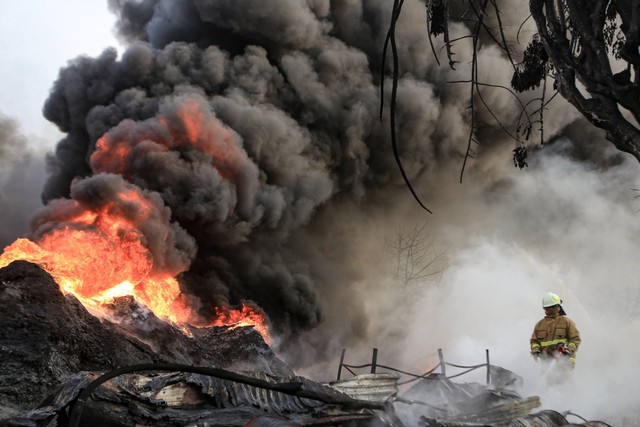 Petugas pemadam kebakaran berusaha memadamkan api yang membakar pabrik plastik di Kalideres, Jakarta Barat, Jumat (19/5/2023). Foto: Fauzan/ANTARA FOTO