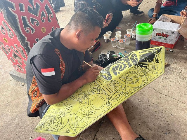 salah satu peserta tengah serius melukis perisai di Pekan Gawai Dayak ke-37 di Rumah Radakng, Pontianak. Foto: Siti Annisa/Hi!Pontianak