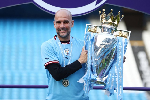 Manajer Manchester City Pep Guardiola mengangkat trofi saat selebrasi setelah memenangkan Liga Inggris, di Stadion Etihad, Manchester, Inggris, Minggu (21/5/2023). Foto: Carl Recine/REUTERS