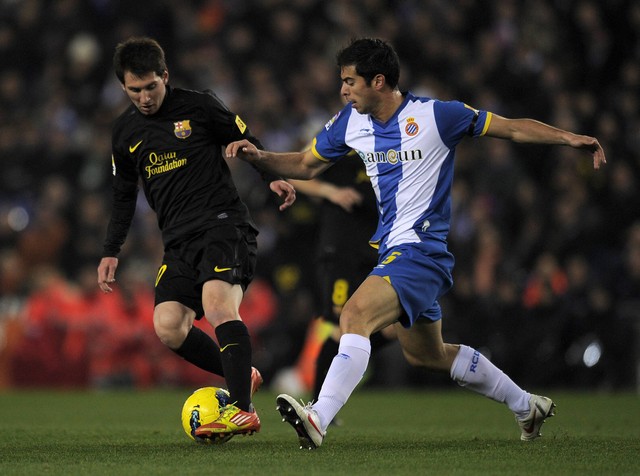Lionel Messi (kiri) saat masih membela Barcelona berduel dengan Jordi Amat (kanan) yang masih memperkuat Espanyol dalam laga Liga Spanyol pada 8 Januari 2012 di Stadion Cornella-El Prat. Foto: LLUIS GEN LLUIS / AFP