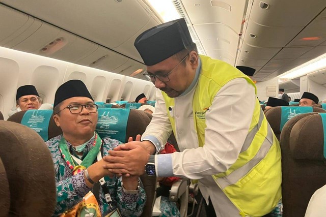 Menteri Agama Yaqut Cholil Qoumas menyalami jemaah calon haji didalam pesawat sebelum diberangkatkan ke Tanah Suci di Bandara Soekarno Hatta, Tangerang, Banten, Rabu (24/5/2023).
 Foto: Kemenag RI