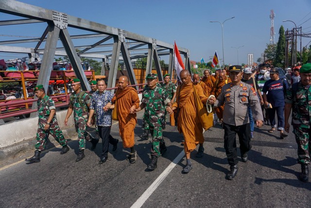 Sejumlah biksu berjalan dengan diiringi polisi, TNI, dan berbagai relawan saat mengikuti ritual Thudong di Kabupaten Pekalongan, Jawa Tengah, Kamis (25/5/2023). Foto: Harviyan Perdana Putra/Antara Foto