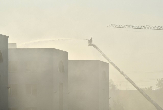 Pemadam kebakaran memadamkan api di sebuah gedung industri yang terbakar usau serangan drone Rusia, di Kiev, Ukraina pada Minggu (28/5/2023). Foto: Sergei Supinsky/AFP
