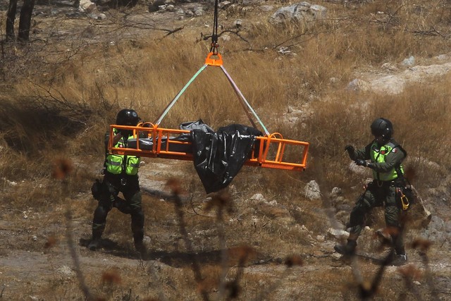 Pakar forensik bekerja dengan beberapa kantong jenazah manusia yang diambil dari dasar jurang dengan helikopter, yang ditinggalkan di komunitas Mirador Escondido di Zapopan, negara bagian Jalisco, Meksiko, Rabu (31/5/2023).
