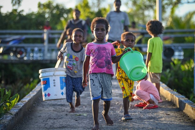 Sejumlah anak membawa ember untuk mengambil air bersih dari reservoir penampung air hujan fasilitas dari pemerintah di Distrik Agats, Kabupaten Asmat, Papua Selatan, Jumat (2/6/2023).  Foto: Aditya Pradana Putra/ANTARA FOTO