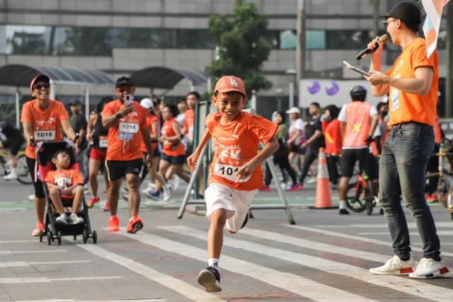 Seorang anak berlari bersama keluarganya di event Fun Run Global 6K-Water for Sumba